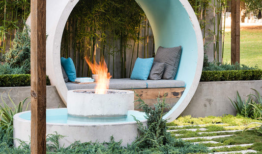 Modern outdoor seating area with fire pit and circular canopy in a garden setting