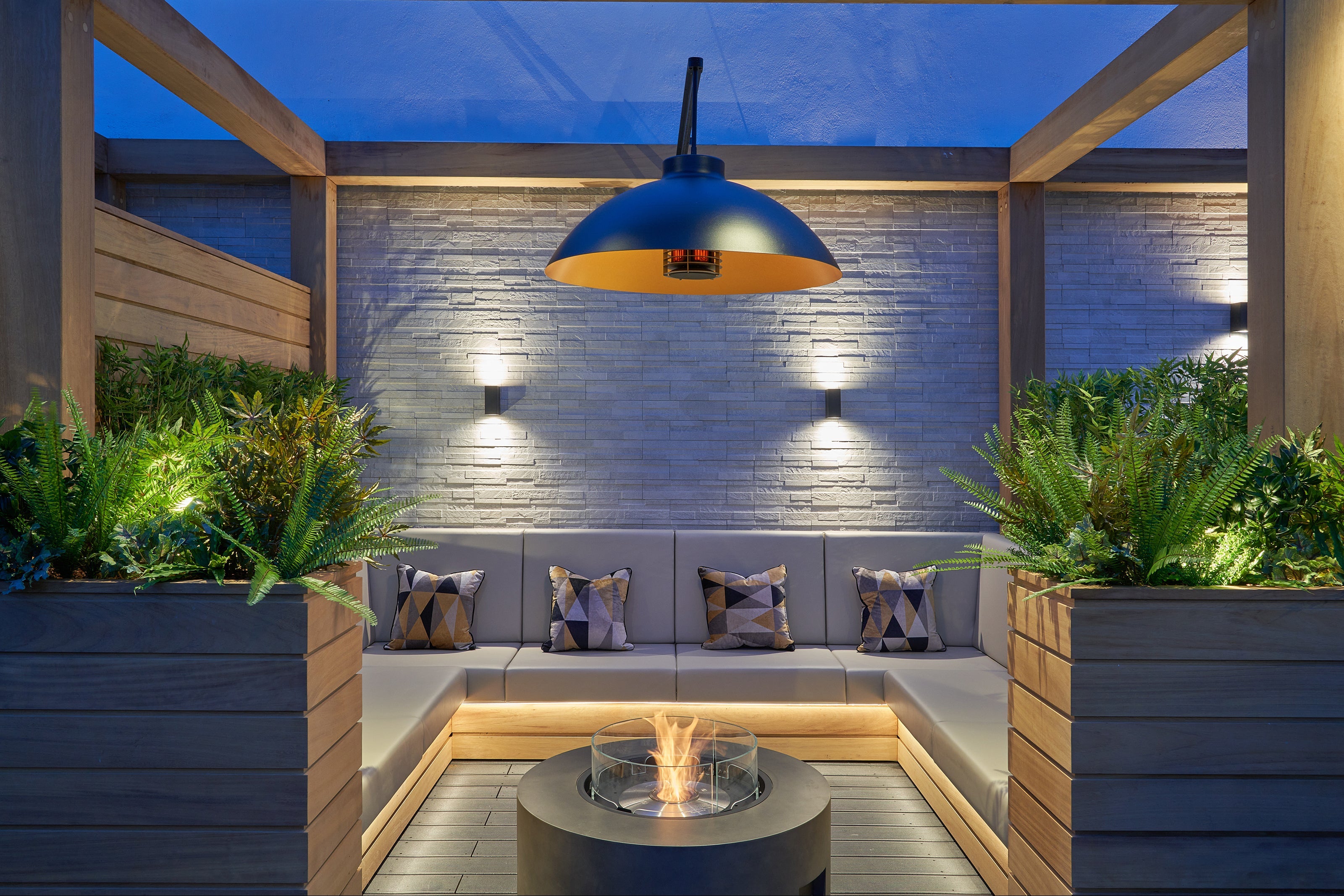 Outdoor patio with seating area, fire pit, and decorative lighting