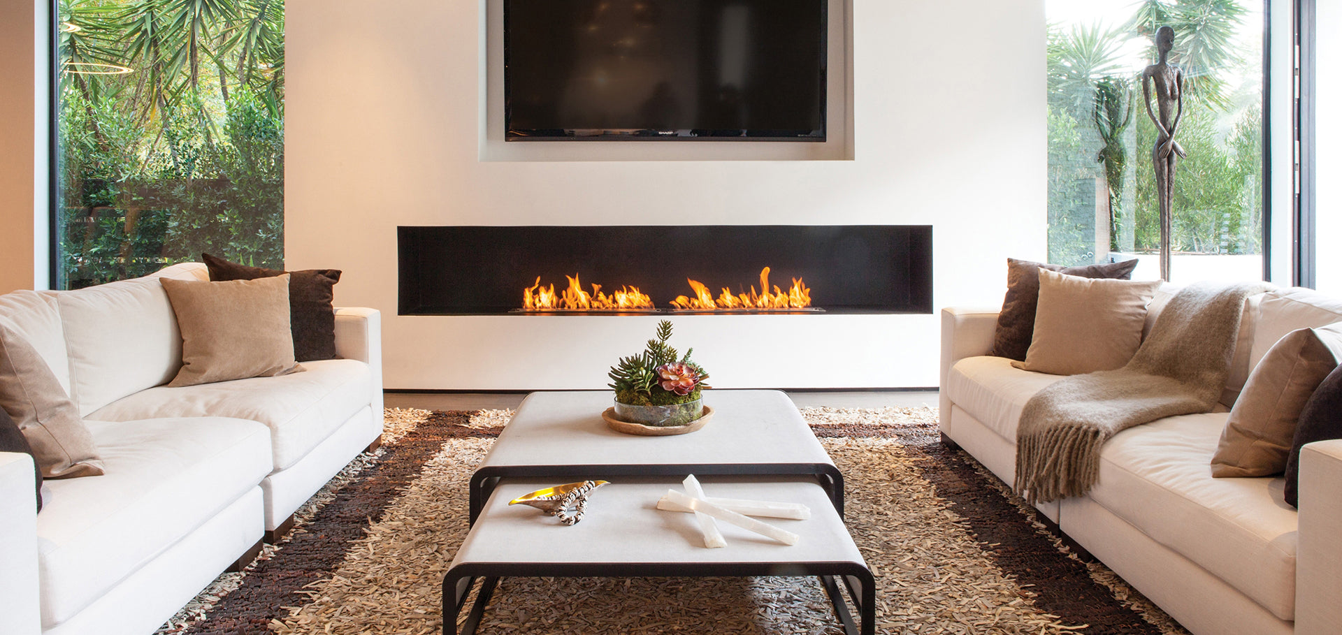 Modern living room with a fireplace, white sofas, and a coffee table.