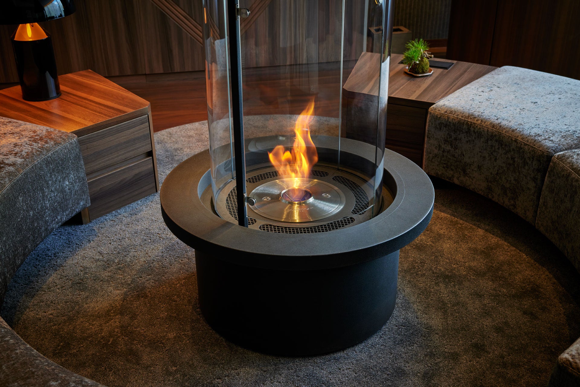 Modern indoor fire pit with flames in a living room setting