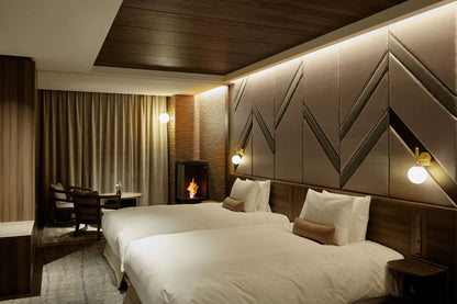 Modern bedroom with a large bed, decorative headboard, and a fireplace.