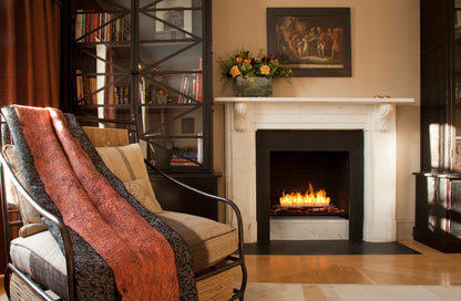 Cozy living room with a fireplace, armchair, and decorative elements.