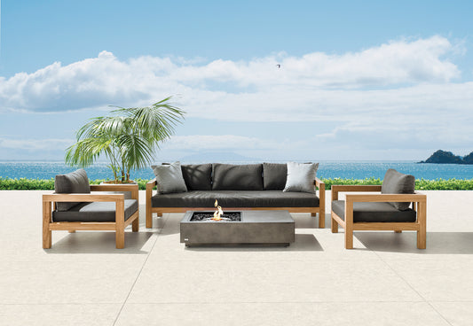 Outdoor patio furniture set with a fire pit table against a scenic ocean backdrop.