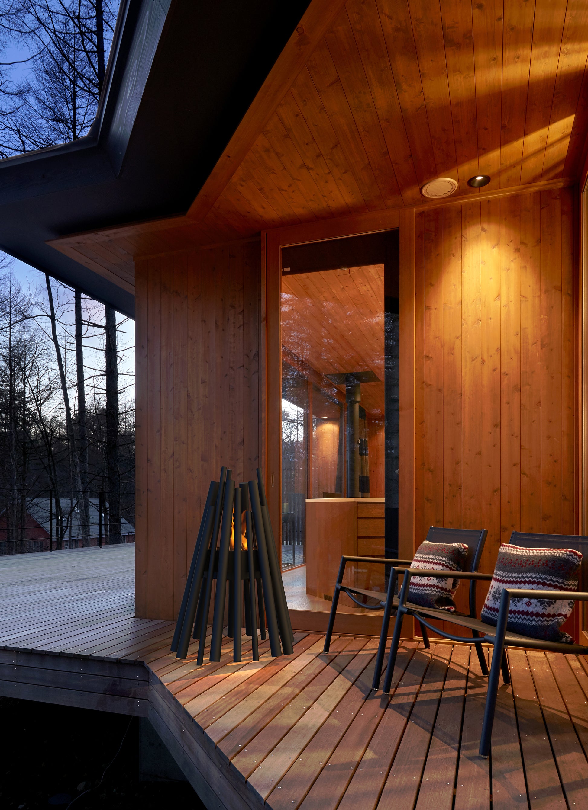 Wooden deck with chairs and firewood, evening setting