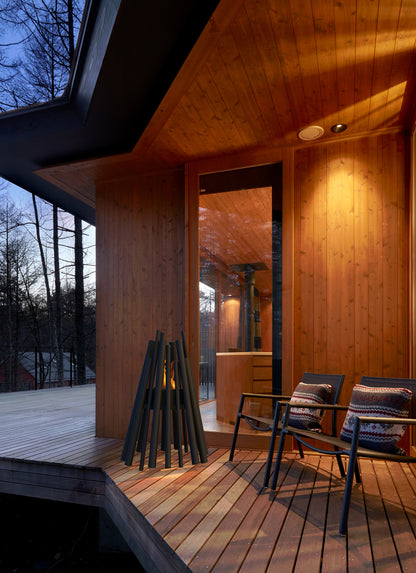 Wooden deck with chairs and firewood, evening setting