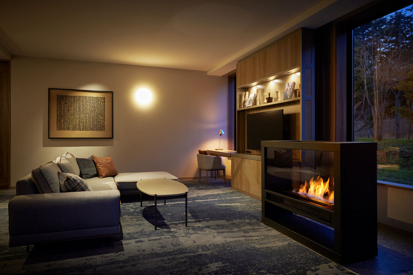 Modern living room with a fireplace, sofa, and large window.