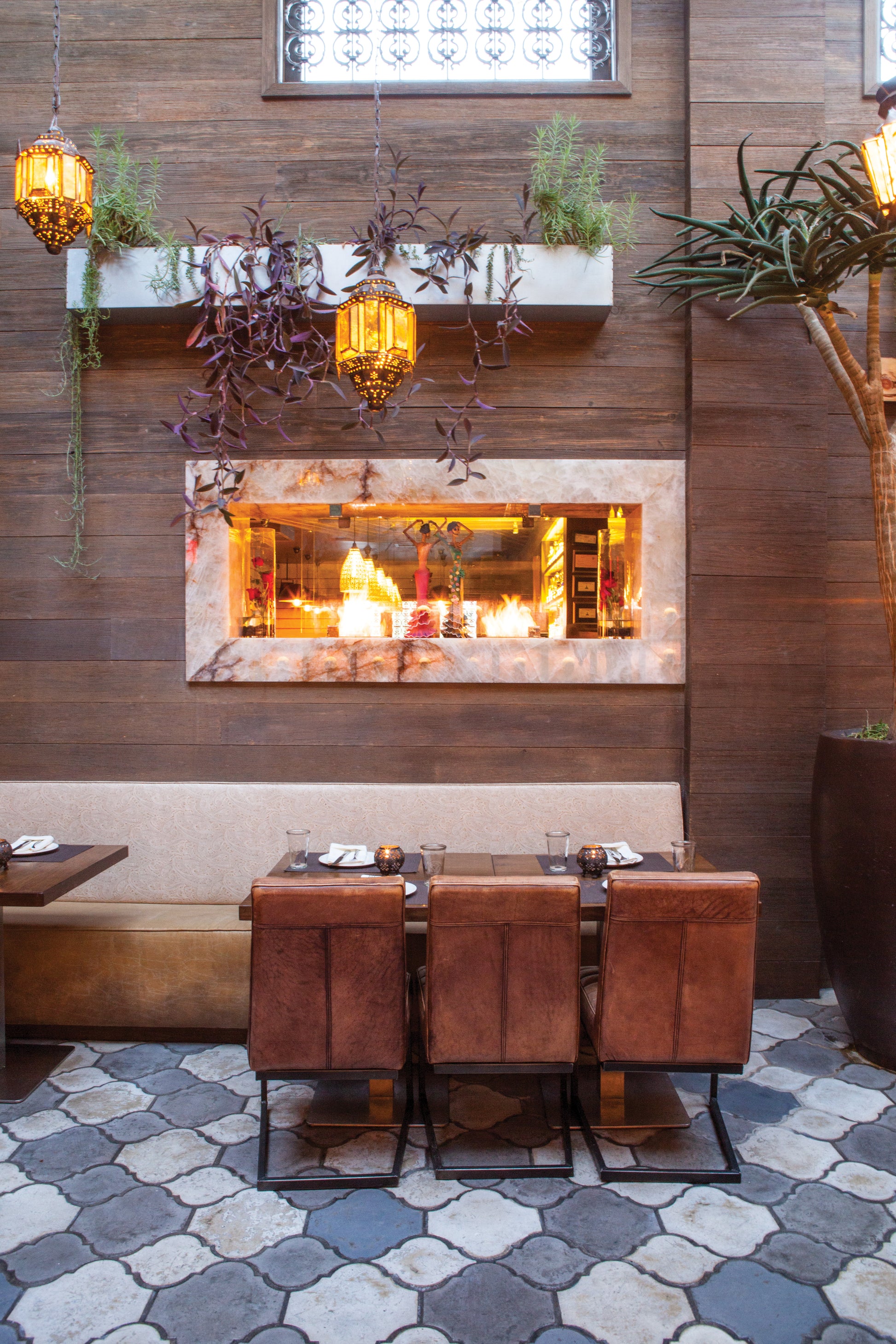 Dining area with a fireplace and wooden chairs in a cozy setting.