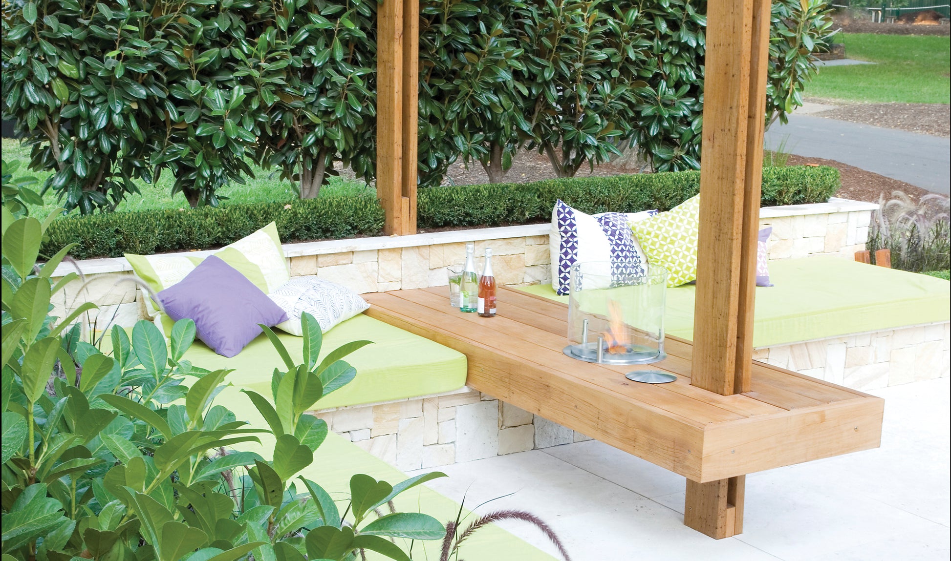 Outdoor seating area with wooden bench and cushions in a garden setting