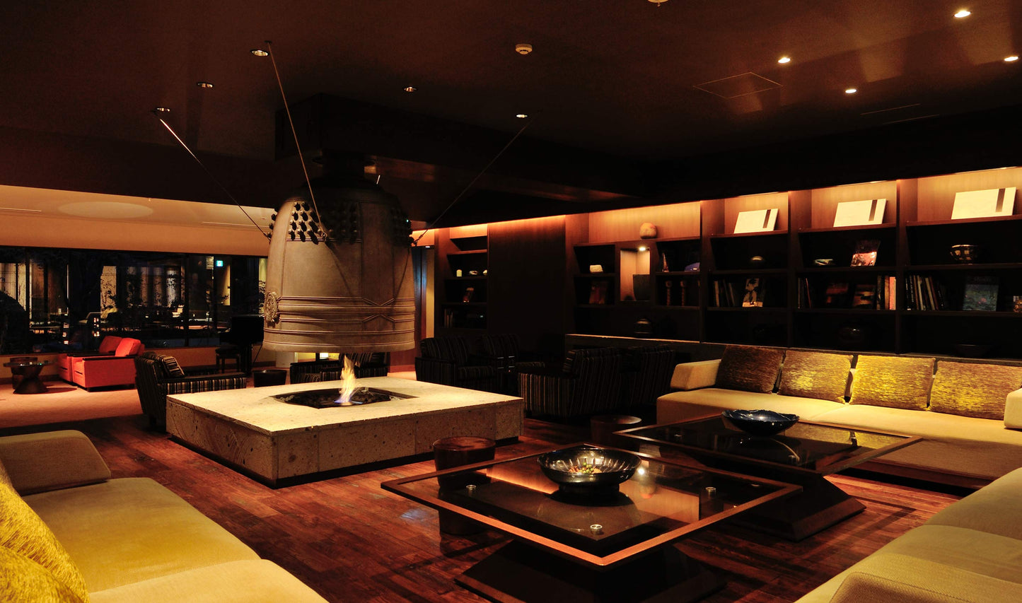 Modern lounge with dim lighting, fire pit, and comfortable seating.