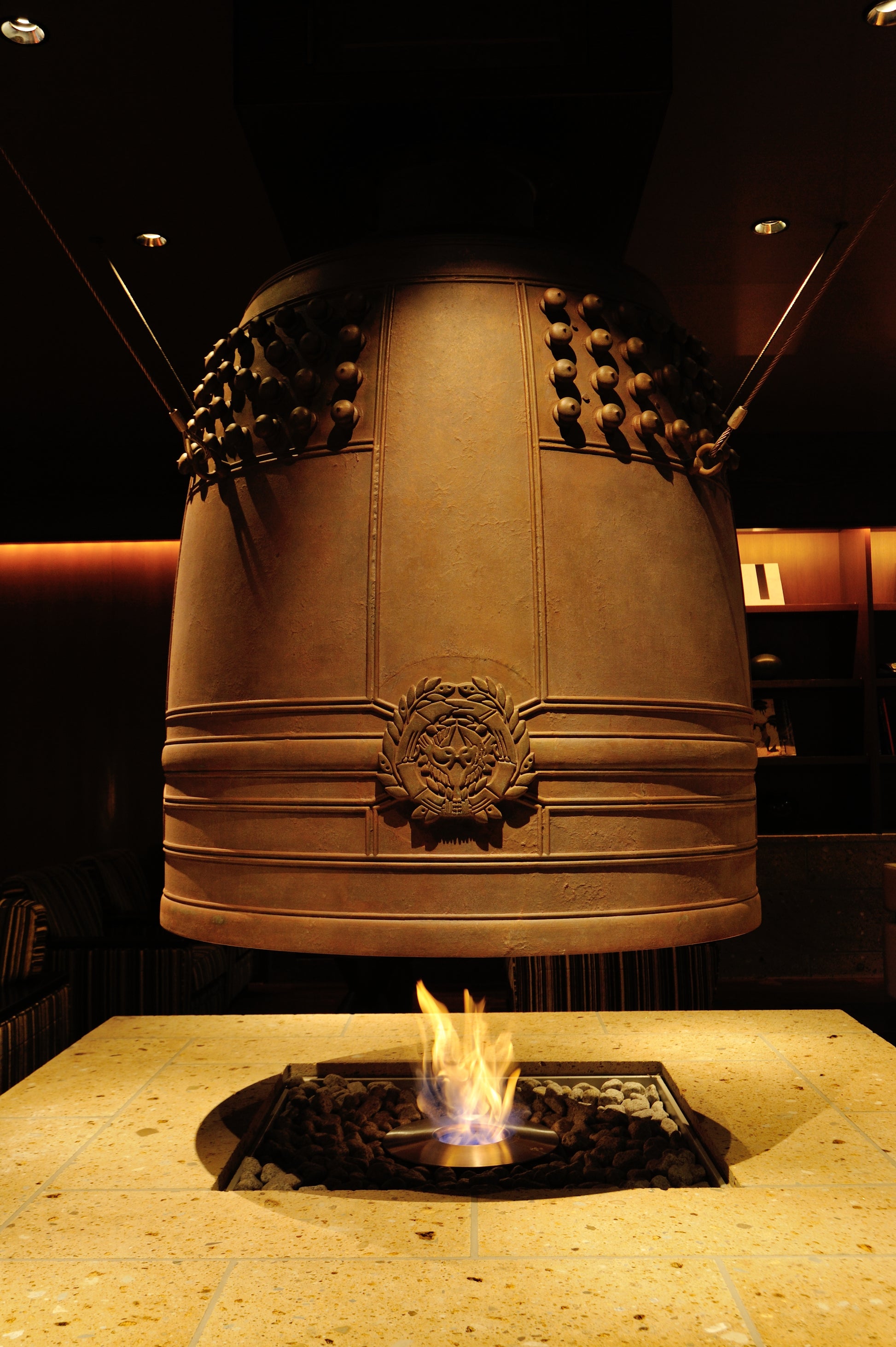 Decorative bell with flames at its base in a dimly lit room