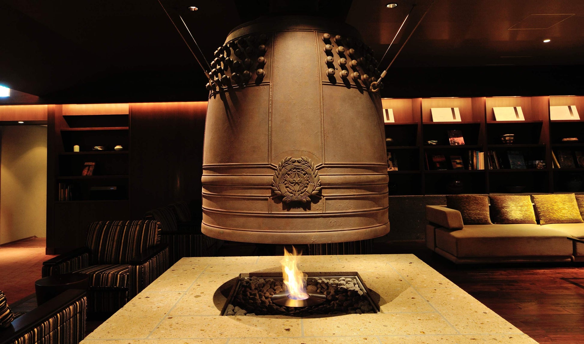Large decorative bell in a dimly lit room with books and seating