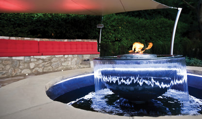 Outdoor fire pit with water feature in a garden setting