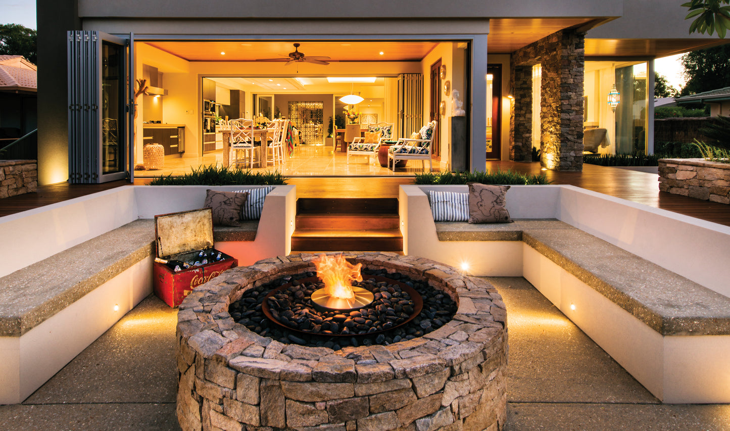 Modern outdoor living space with a fire pit and seating area.