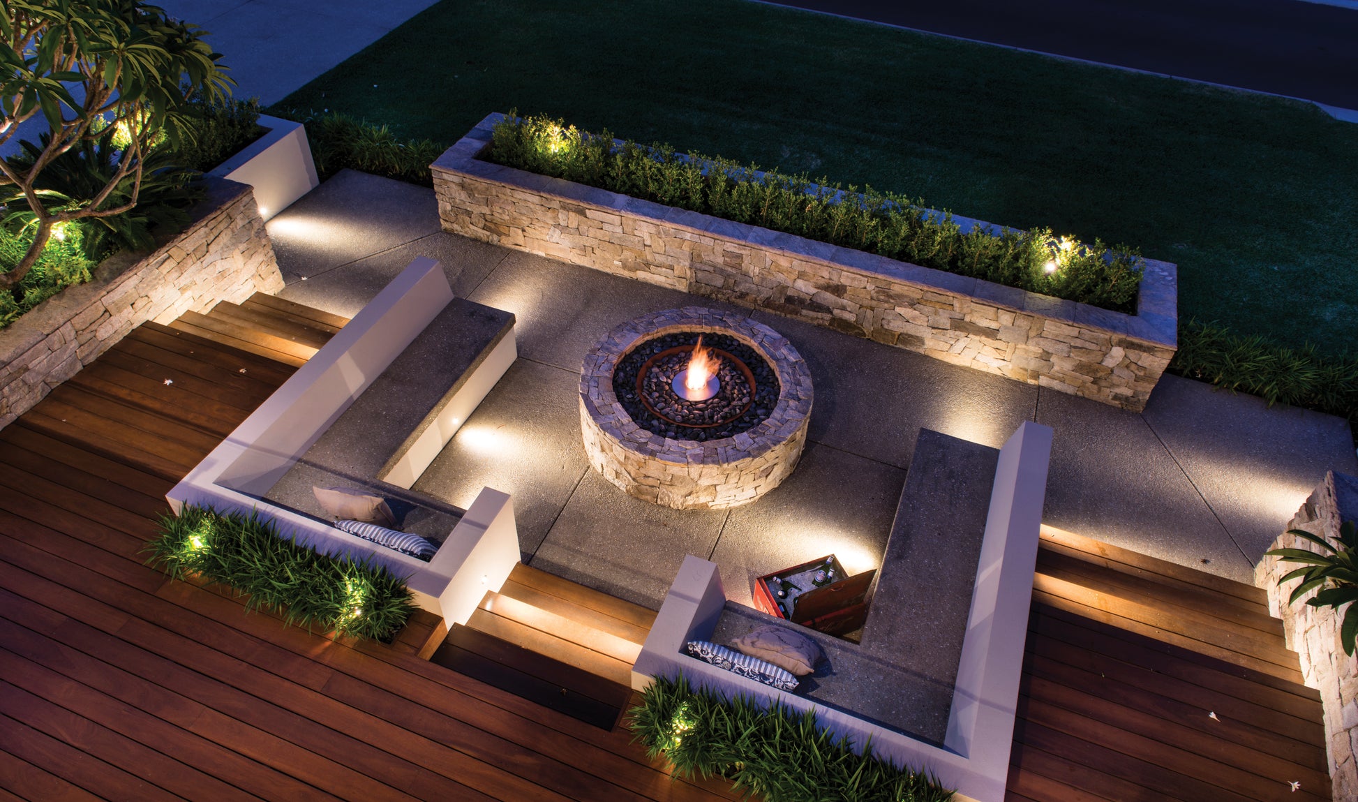 Outdoor patio with fire pit and seating area at night