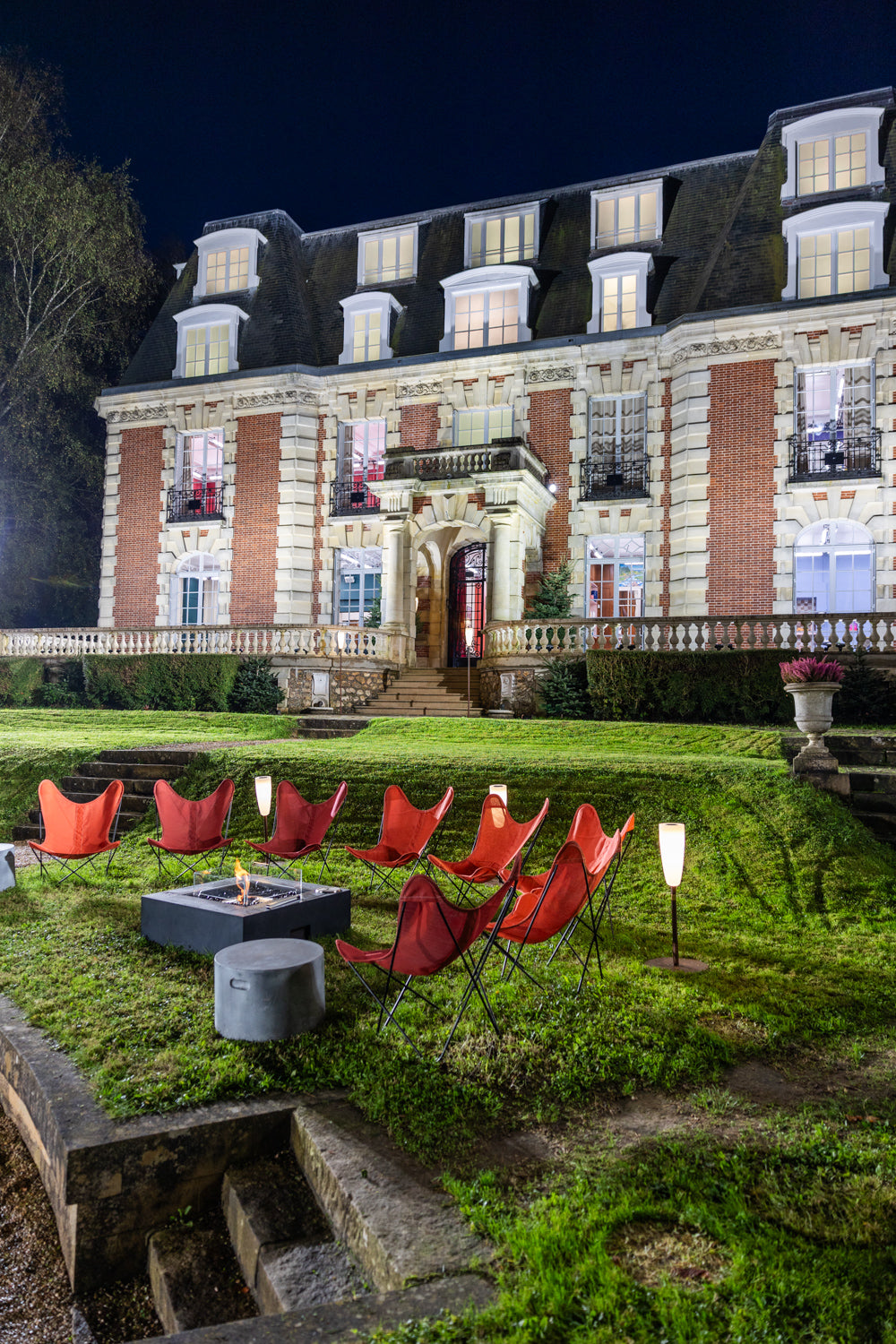 Elegant mansion with outdoor seating area at night