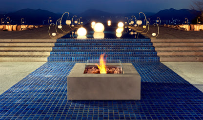 Fire pit on a blue tiled patio with decorative lights and mountains in the background