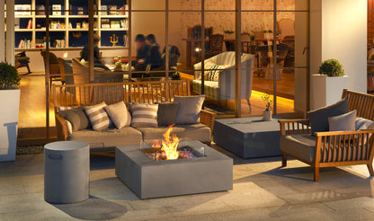Outdoor seating area with fire pit table and cushions in a modern setting