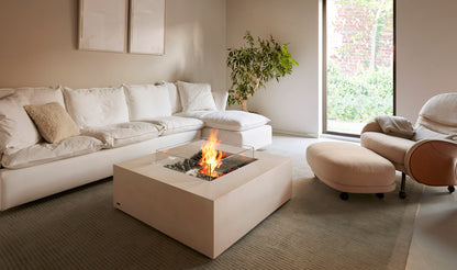 Modern living room with a fire pit table and white sectional sofa.