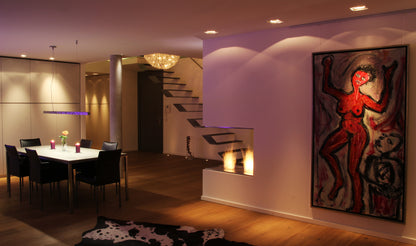 Modern interior with a dining area, staircase, and abstract artwork on the wall.