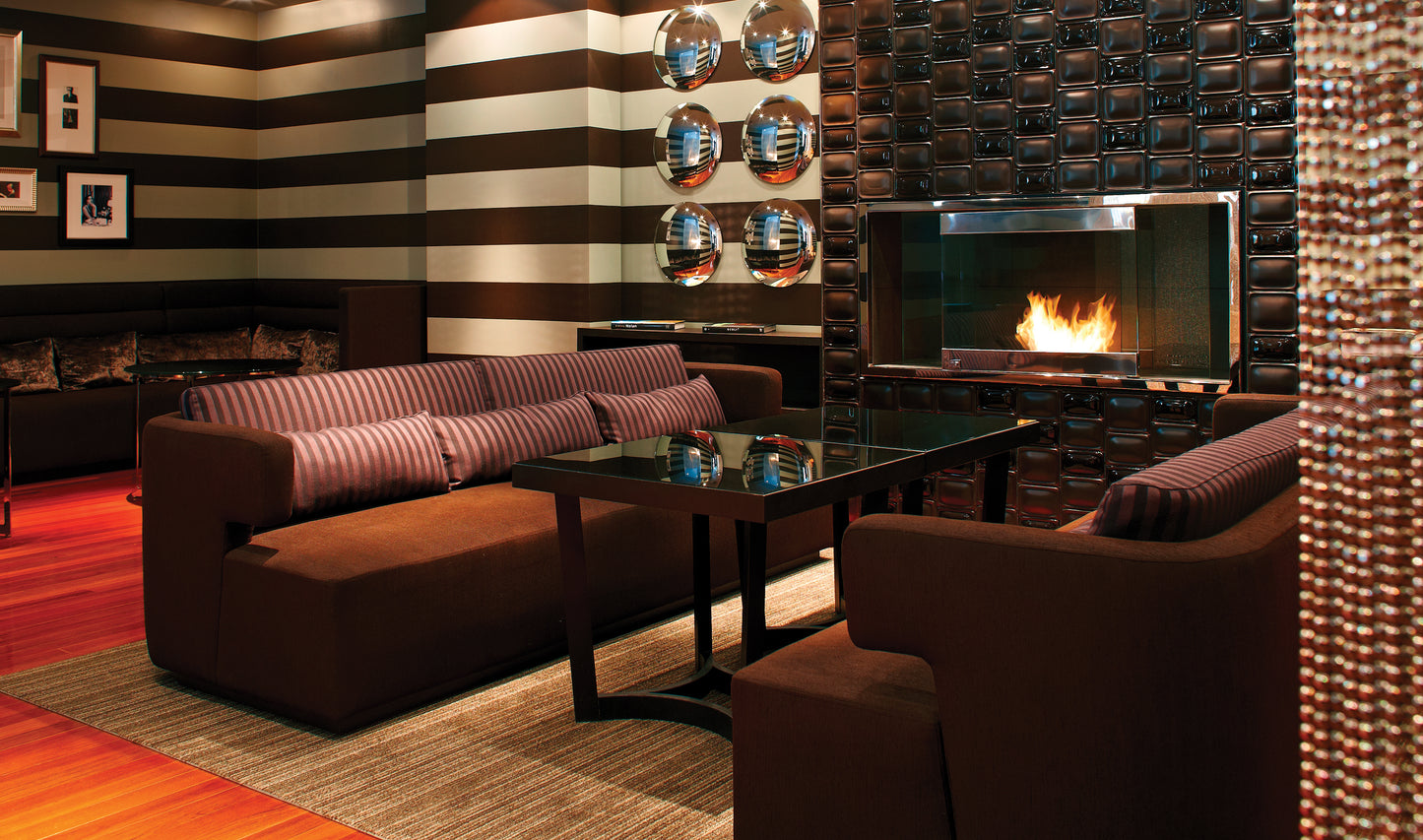 Modern living room with striped walls, a fireplace, and decorative items.