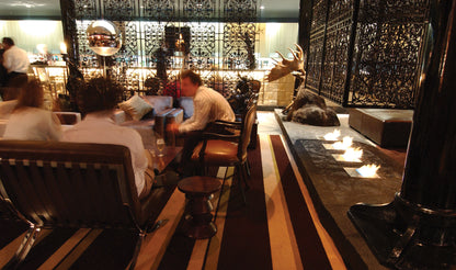 Dining area with patrons at a restaurant, featuring a bar counter with candles.