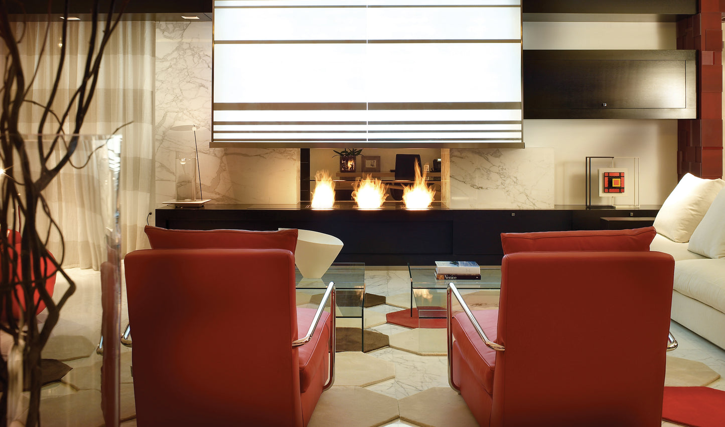 Modern living room with red chairs, a fireplace, and decorative elements.