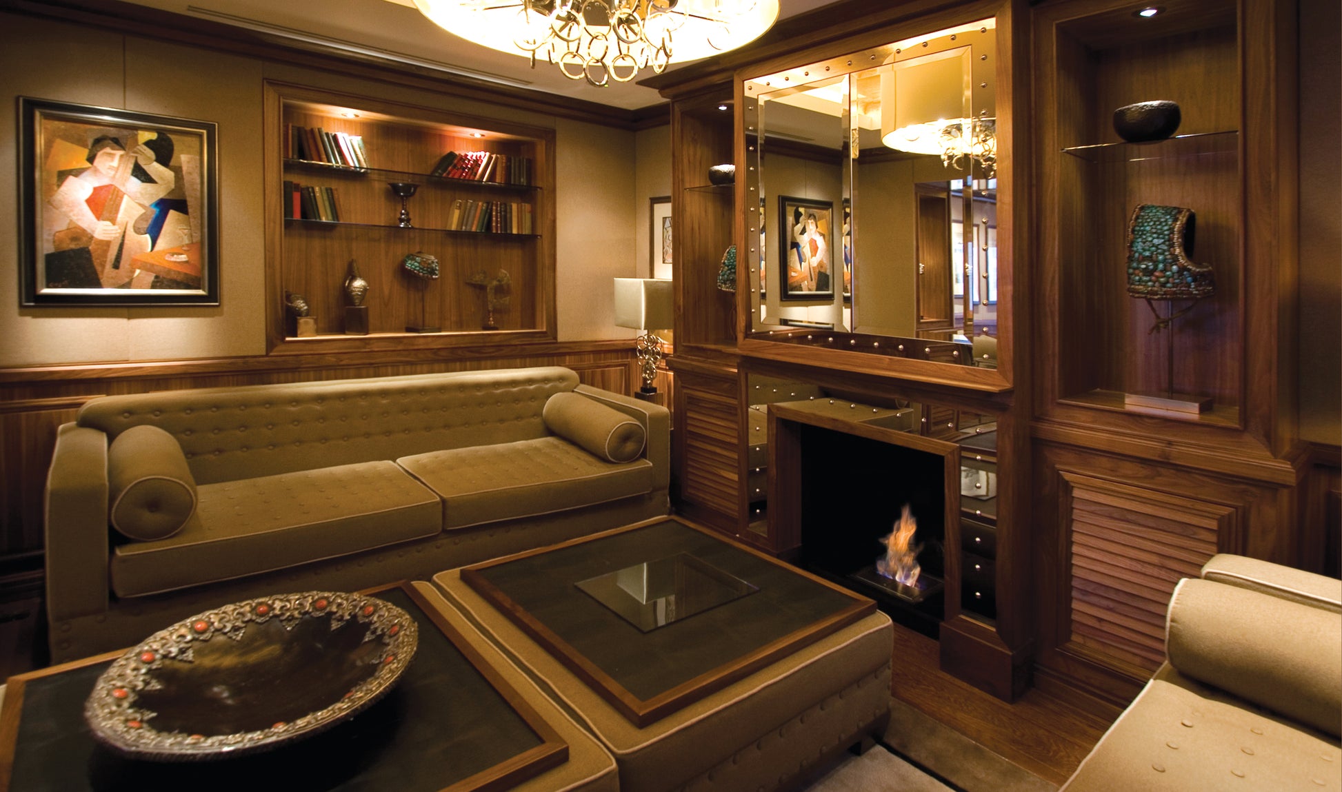Luxury living room with beige sofa, wooden shelves, and a fireplace.