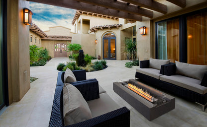 Outdoor patio with modern furniture and a fire pit in a residential setting