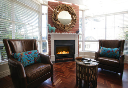 Living room with two brown leather chairs, a fireplace, and decorative elements.
