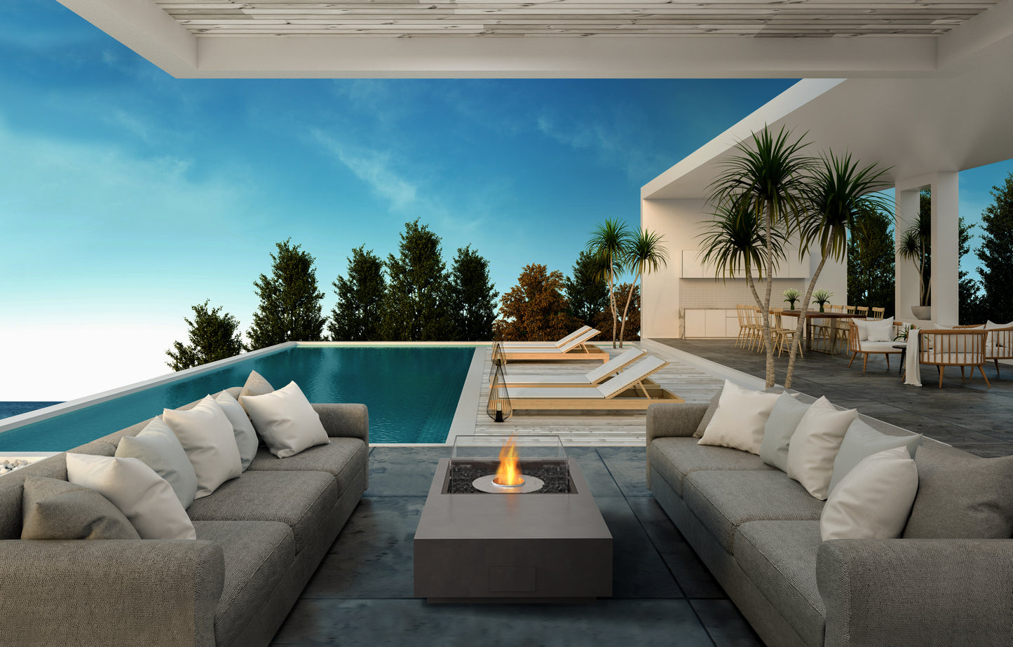 Modern outdoor patio with gray sofas, fire pit, and pool view
