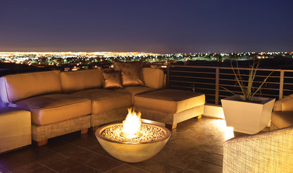 Outdoor patio with a fire pit and cityscape view at night