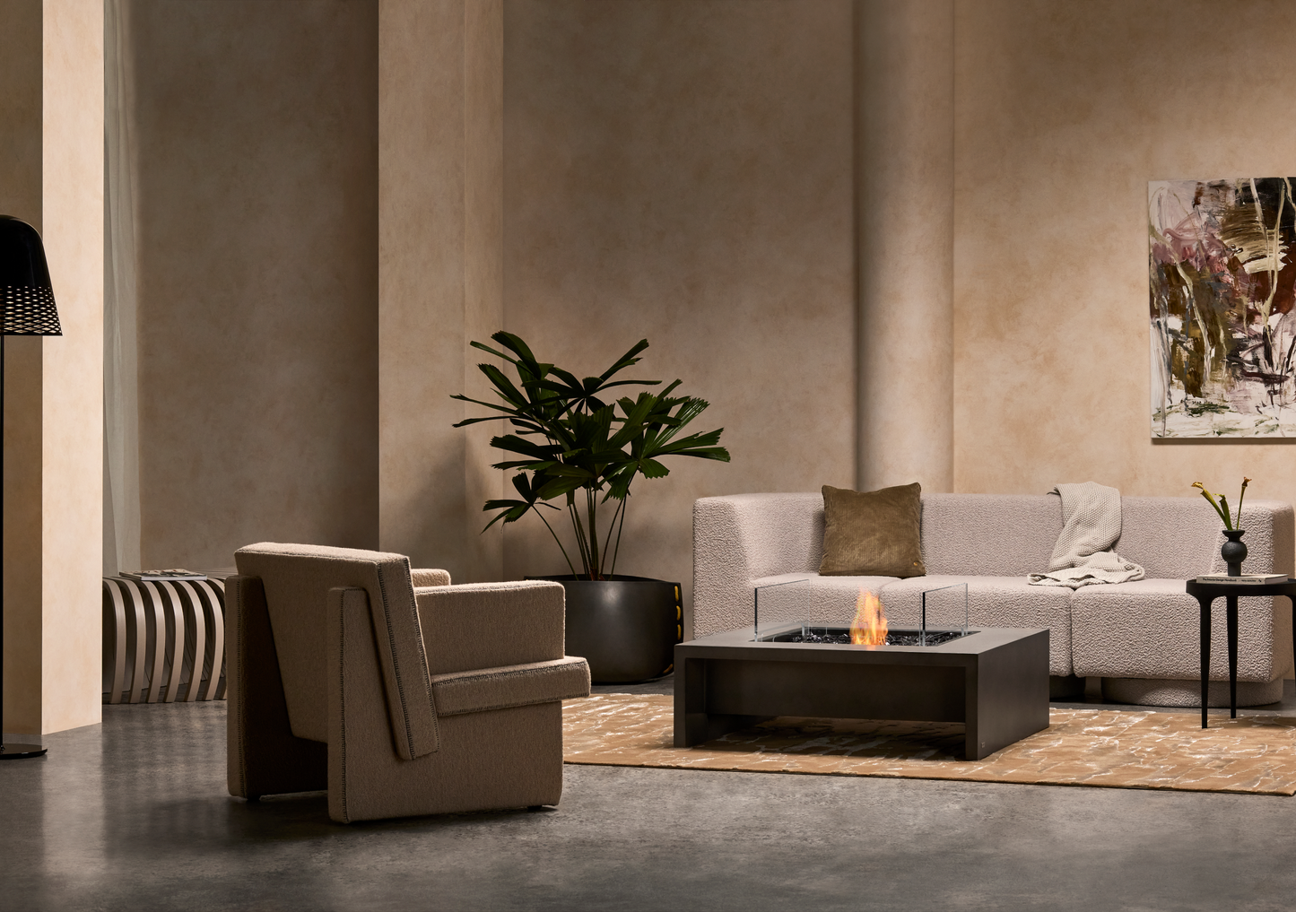 Modern living room with a beige armchair, gray sofa, and decorative elements.