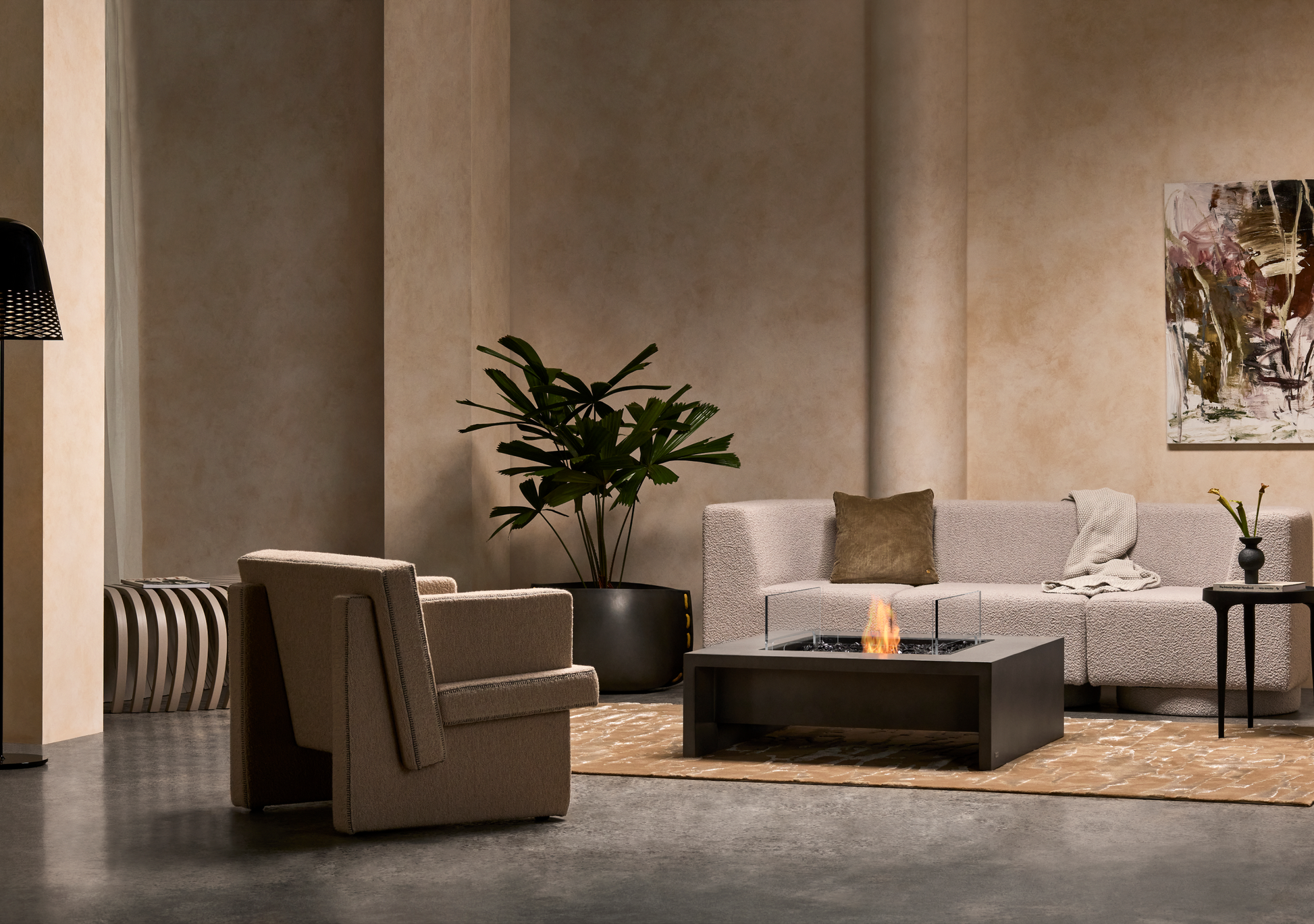 Modern living room with a beige armchair, gray sofa, and decorative elements.