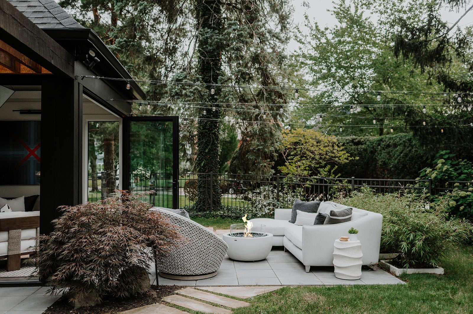 Outdoor patio area with modern furniture and greenery