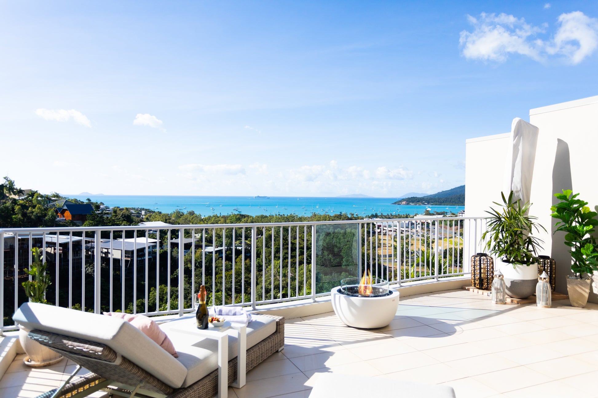 Modern patio with lounge chairs, table, and ocean view