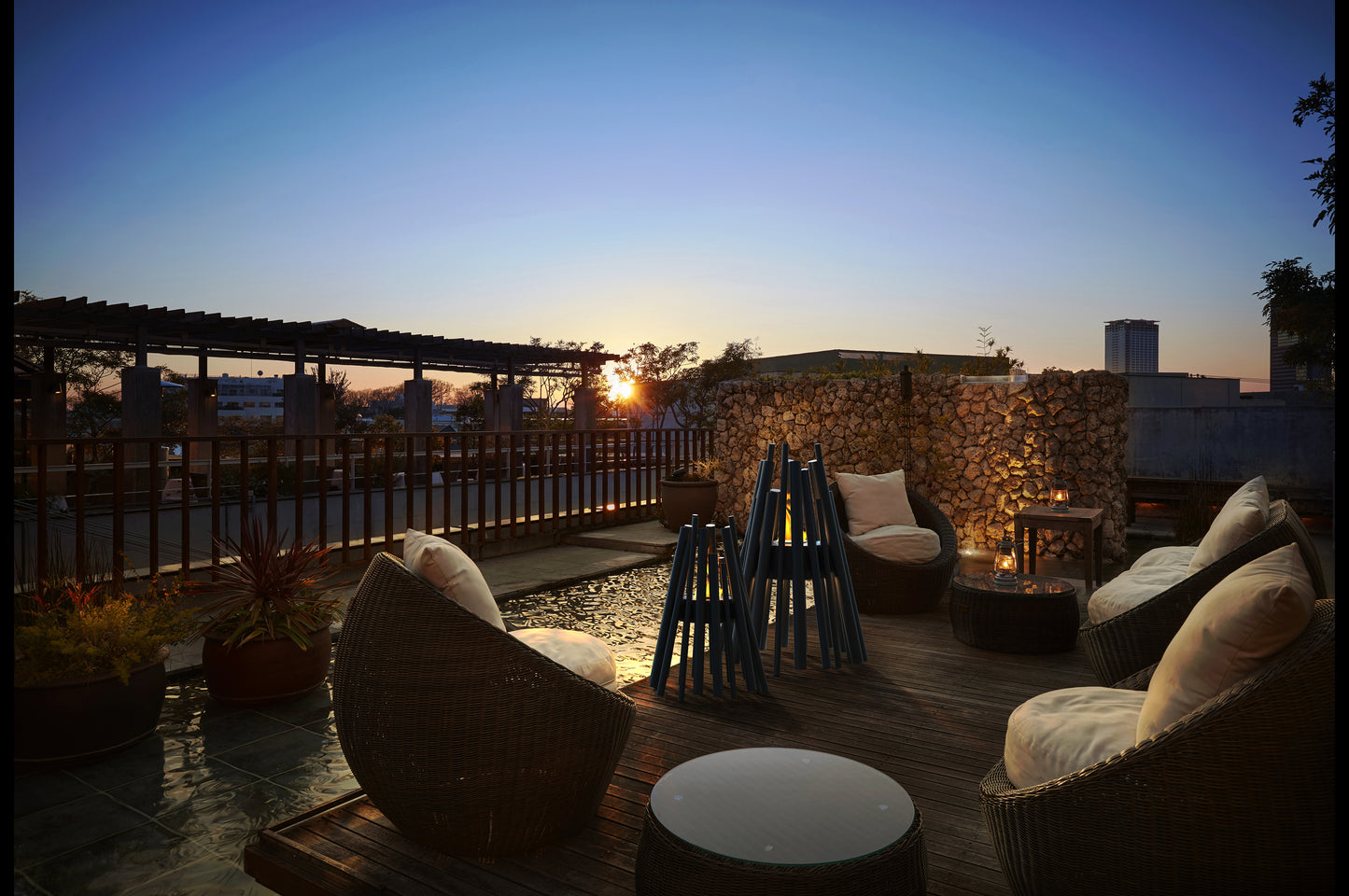Evening rooftop scene with chairs and a sunset.