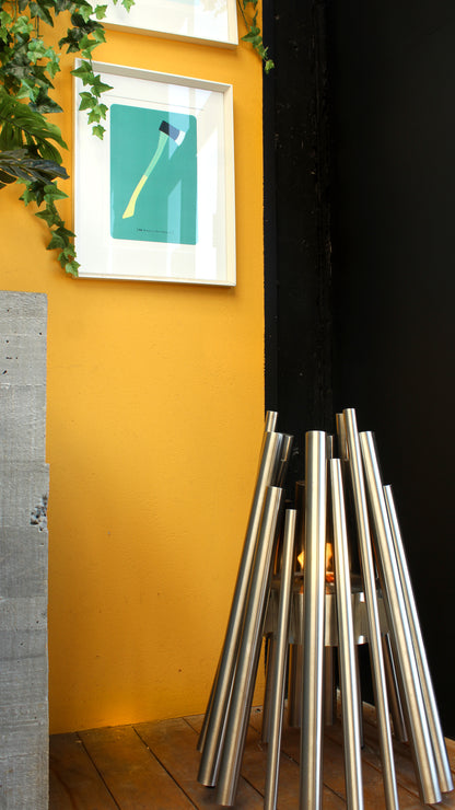 Metallic sculpture against a yellow wall with a framed picture