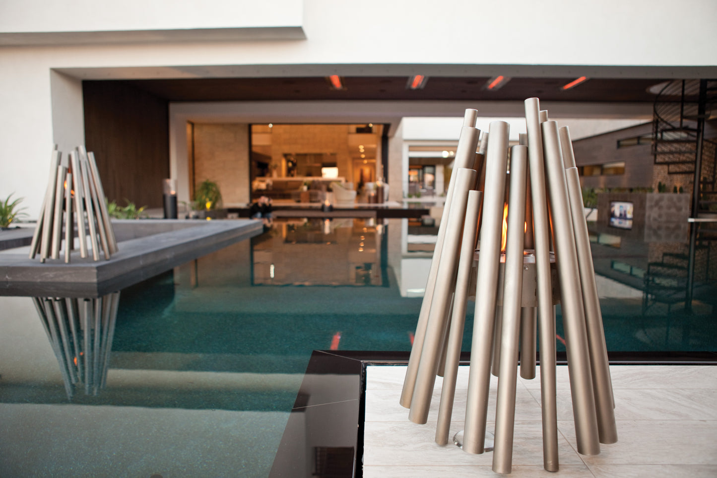 Modern outdoor setting with a pool and decorative metal structures.