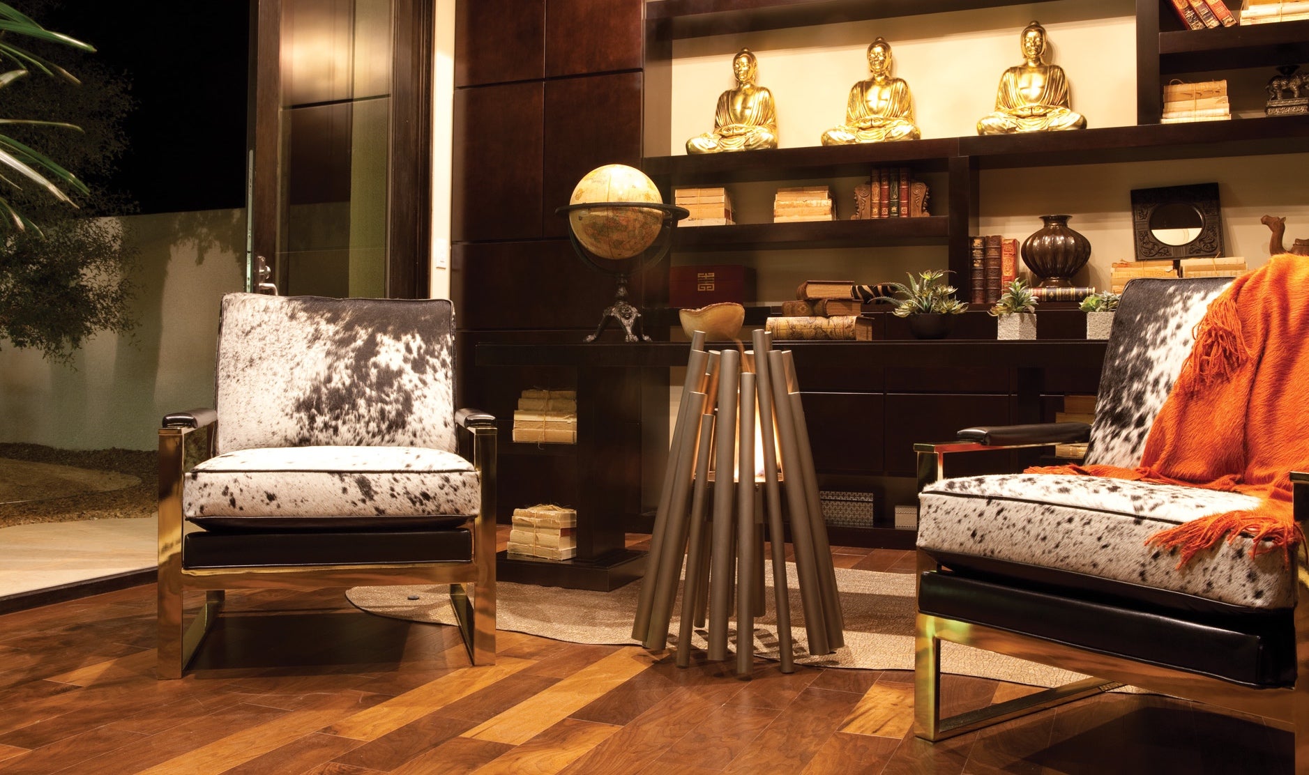 Decorative interior with chairs, a table, and shelves with decorative items.