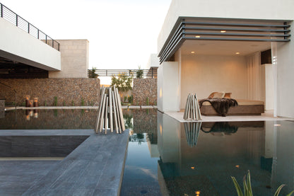 Modern outdoor setting with a pool, lounge area, and architectural elements.