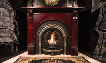 Decorative fireplace with a lit fire, surrounded by ornate furniture.
