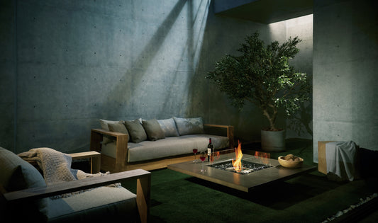Modern living room with a fire pit, sofa, and decorative plants.