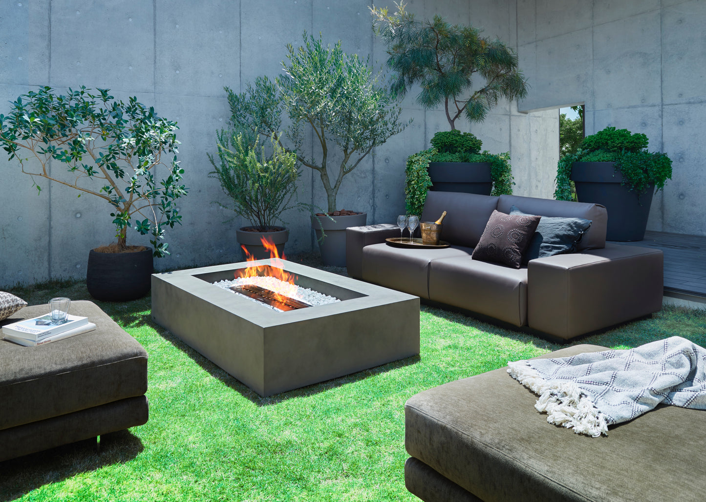 Outdoor patio with fire pit, seating area, and potted plants.
