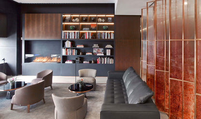 Modern living room with a fireplace, bookshelf, and decorative elements.