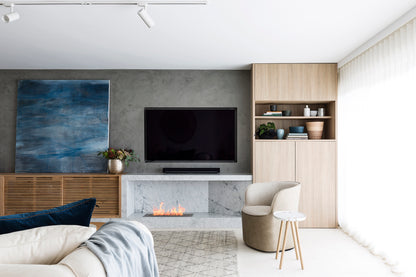 Modern living room with a television, fireplace, and decorative items.