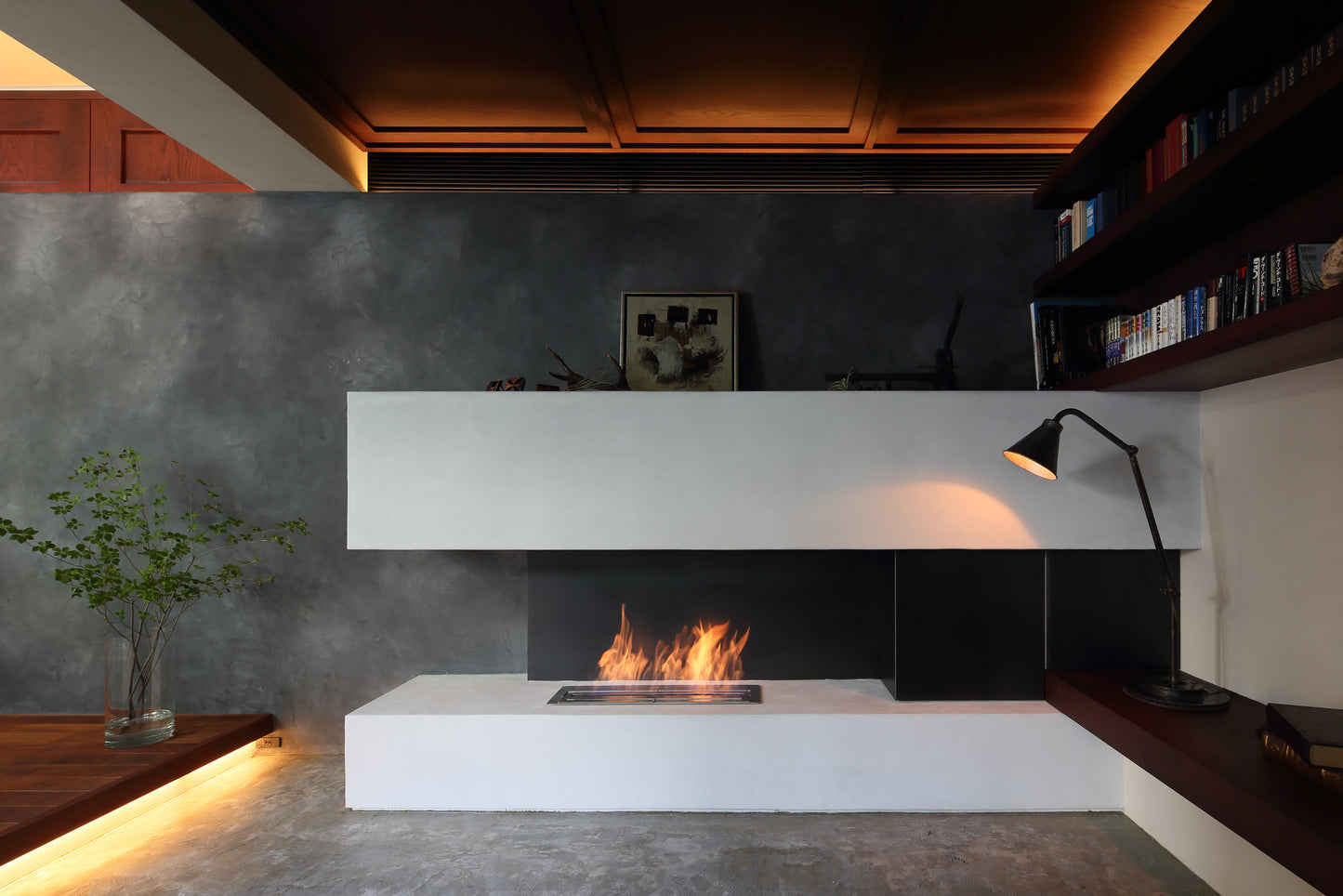 Modern living room with a white fireplace against a gray wall.