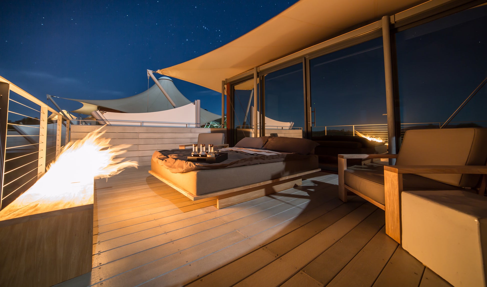 Outdoor deck with seating area, fire pit, and starry sky
