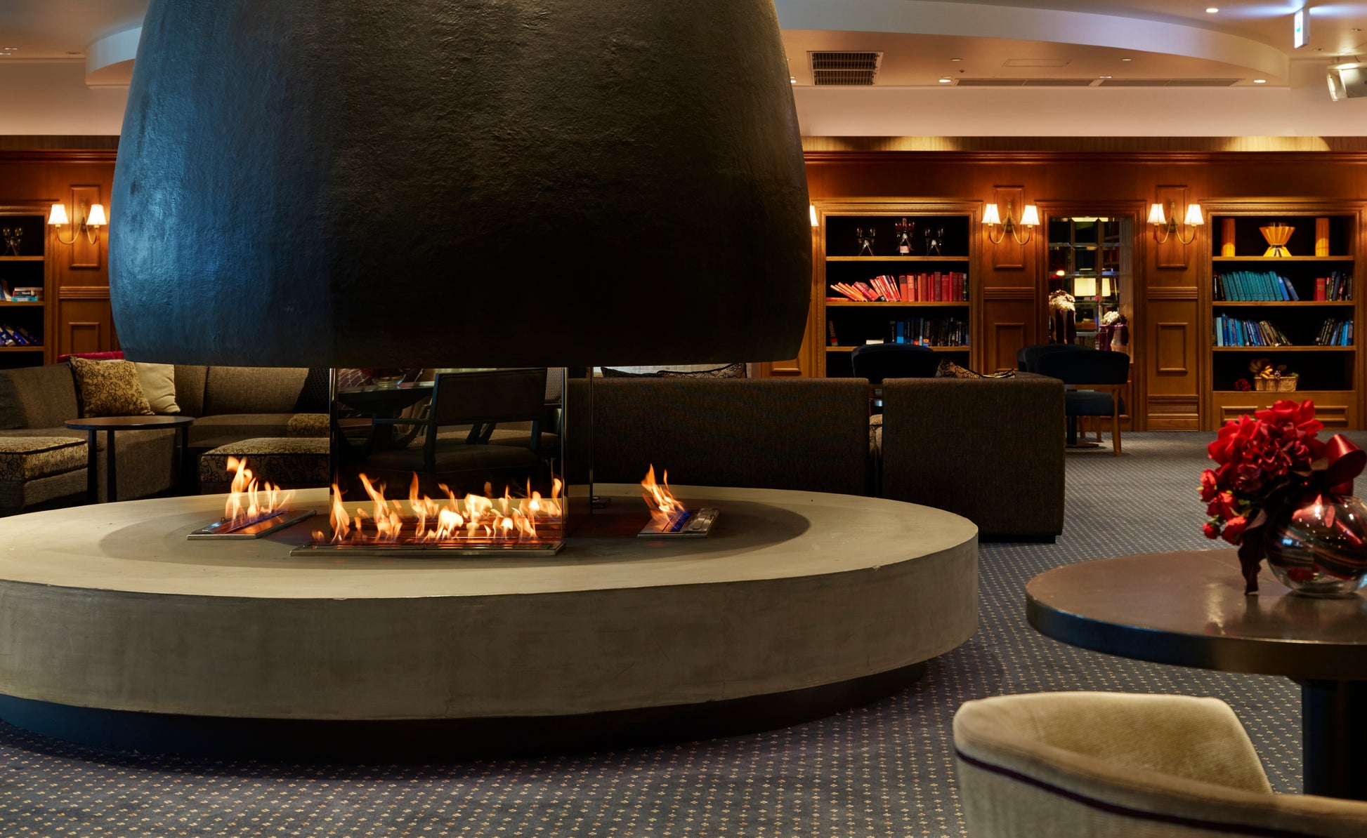 Modern living room with a large fireplace and bookshelves.