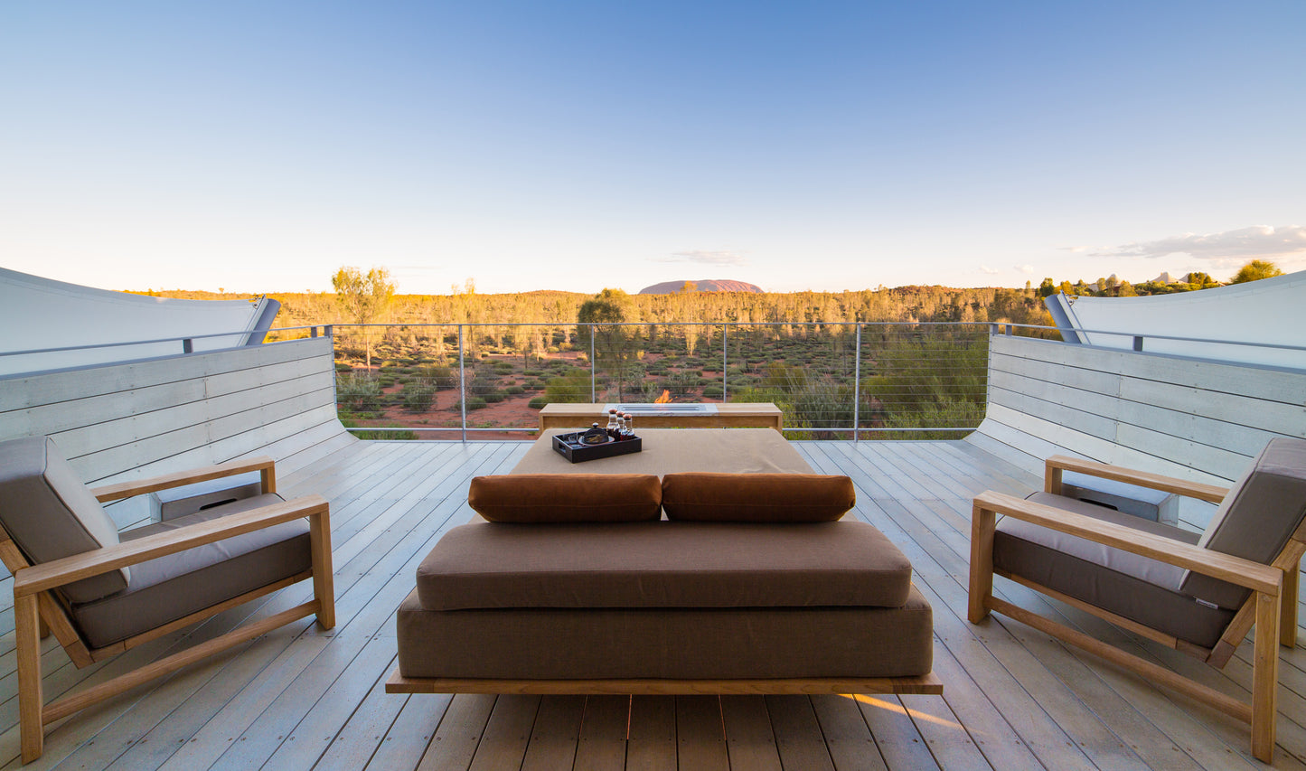 Modern outdoor furniture set on a wooden deck with a scenic view.