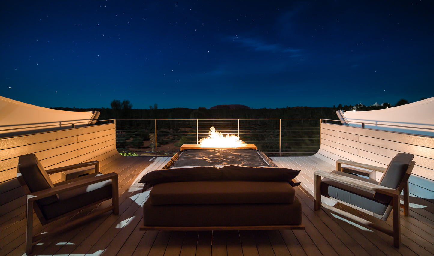 Outdoor deck with fire pit and chairs under a starry night sky